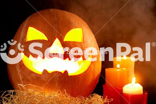 Image Of Big Pumpkin With Burning Candle Inside And Three Candles Near By